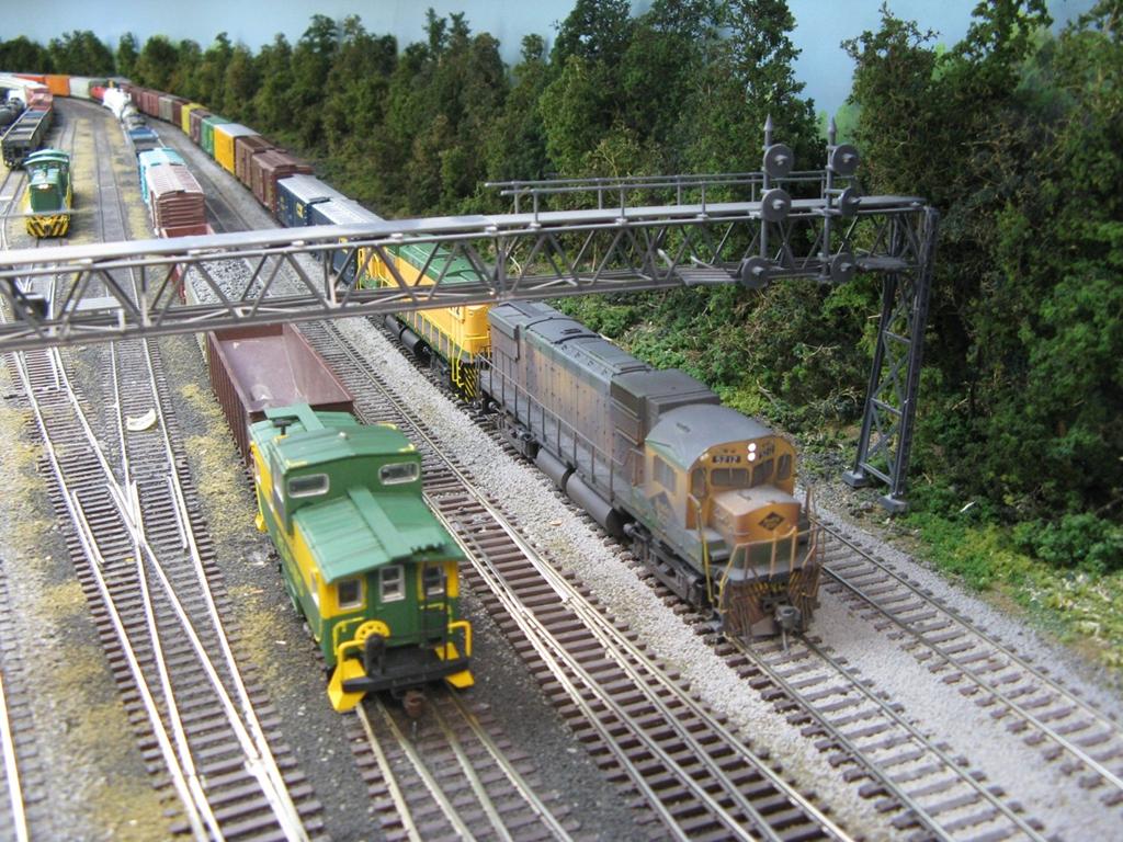 A westbound’s caboose has cleared under the signal bridge into Abrams Yard while an eastbound passes on the main, heading to Port Richmond